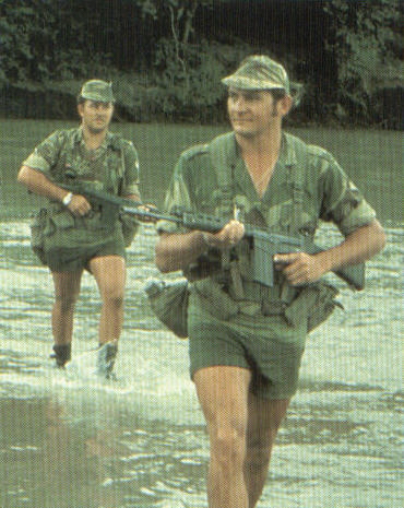 Scouts cross a river deep in the Rhodesian bush.